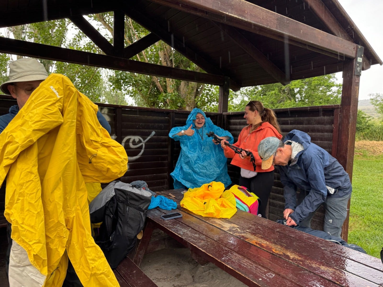Pilgrims getting rain gear on at covered rest area