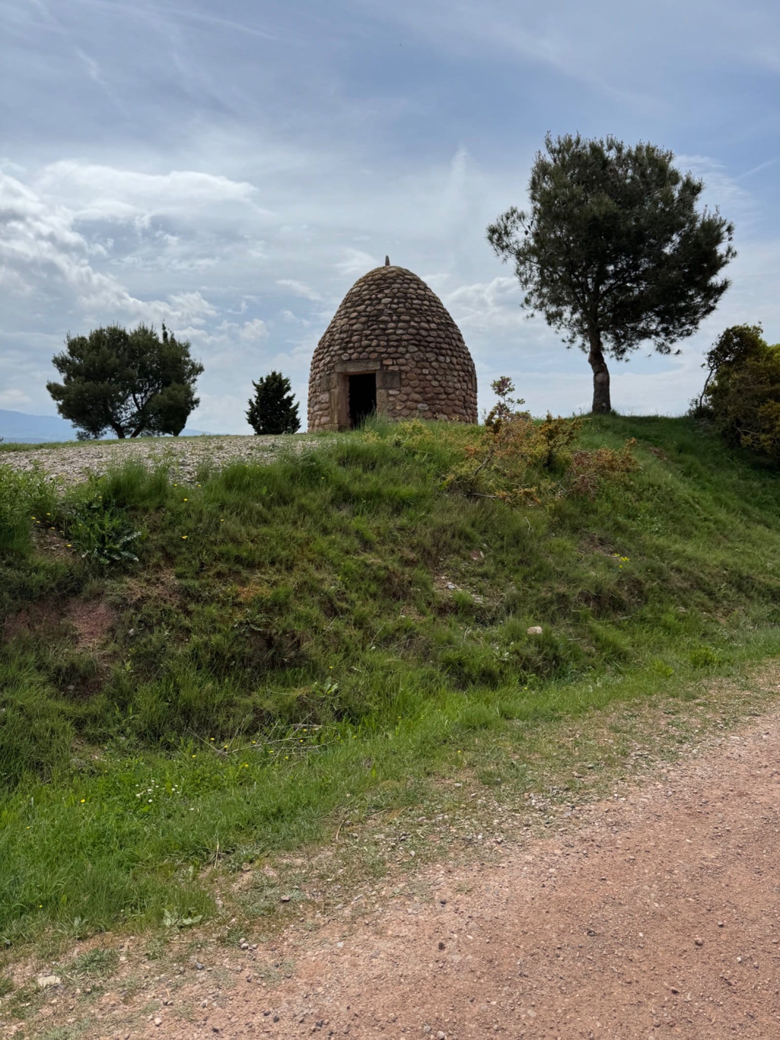 Traditional stone hut on grassy hillside