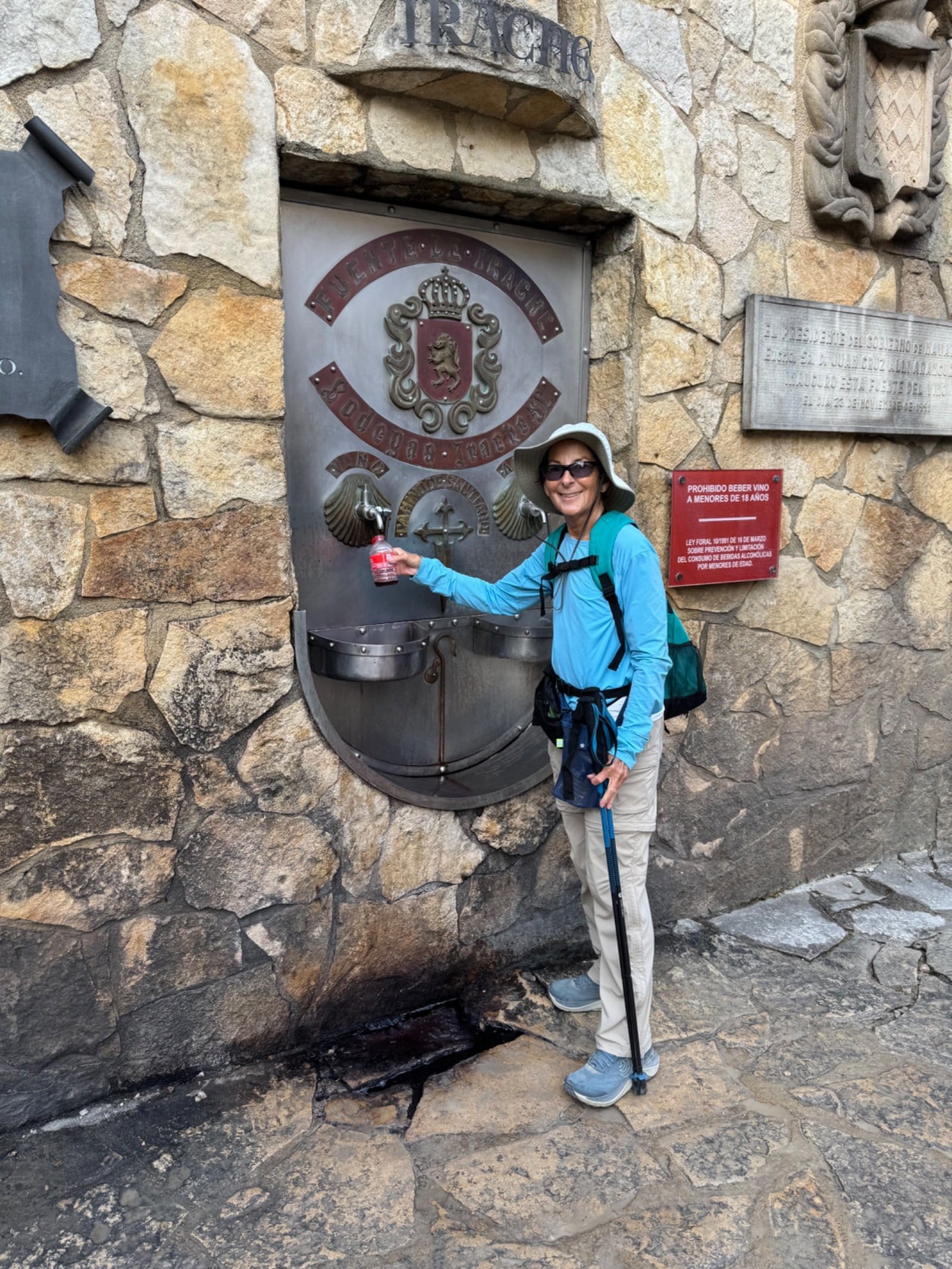 Pilgrim sampling wine at Irache monastery fountain