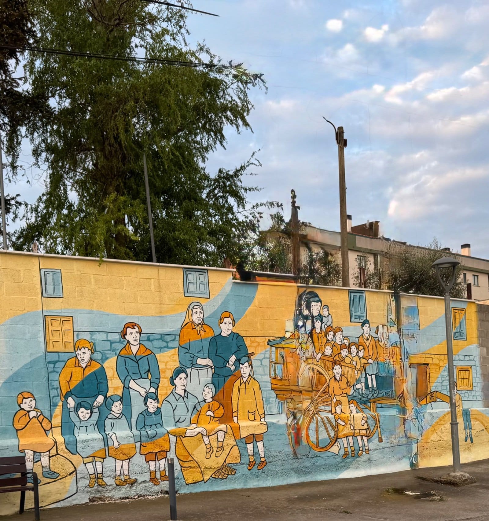 Historical village scene mural with ox cart and families