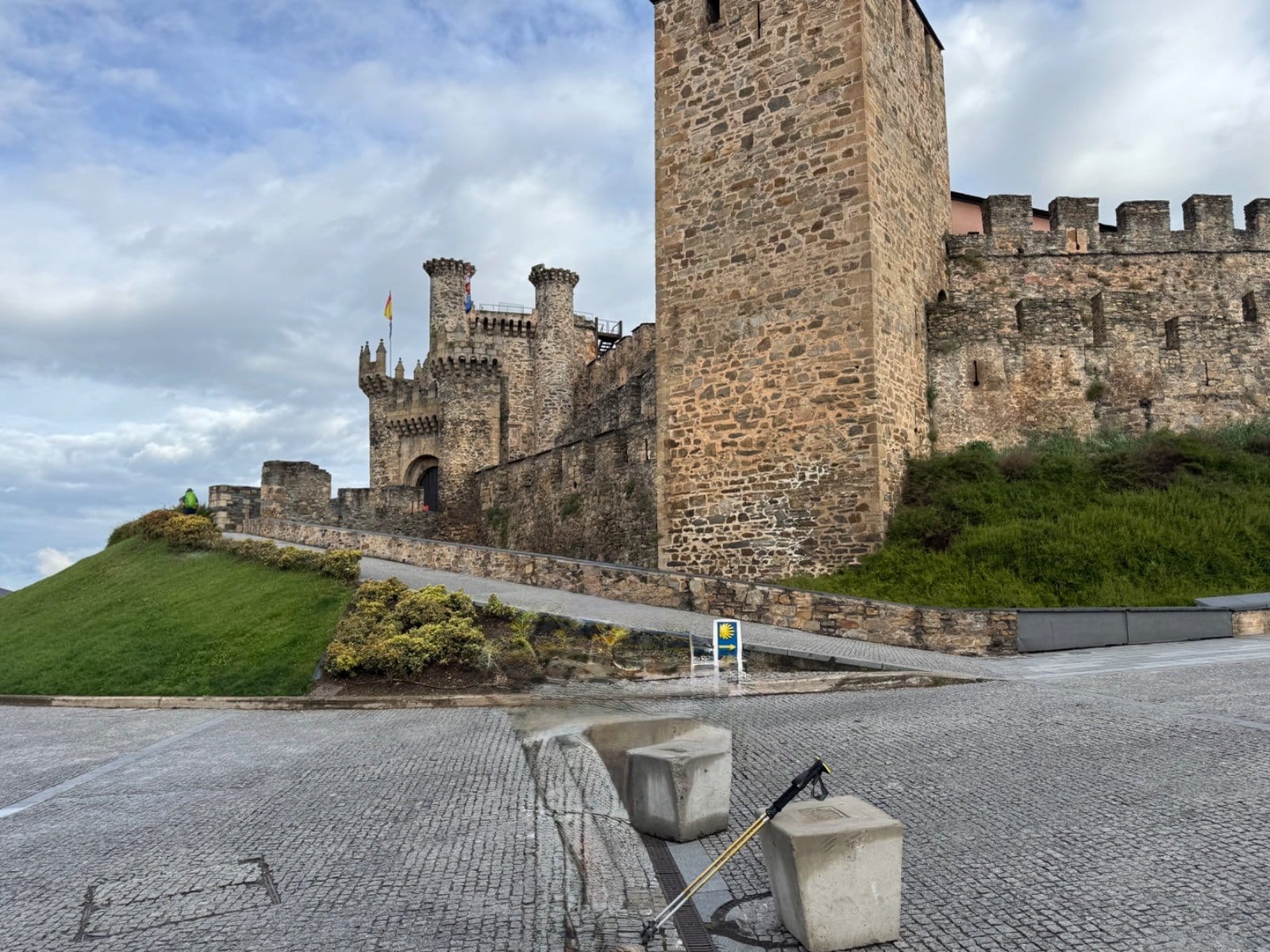Castle exterior with Camino marker and walking poles