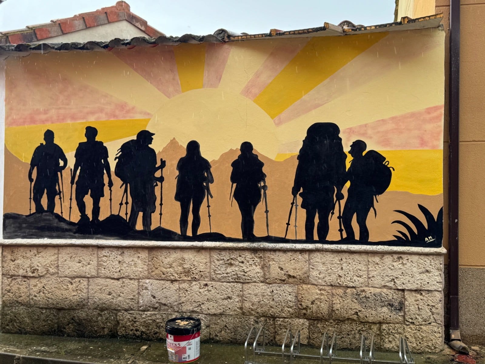Sunrise silhouettes of pilgrims with walking sticks