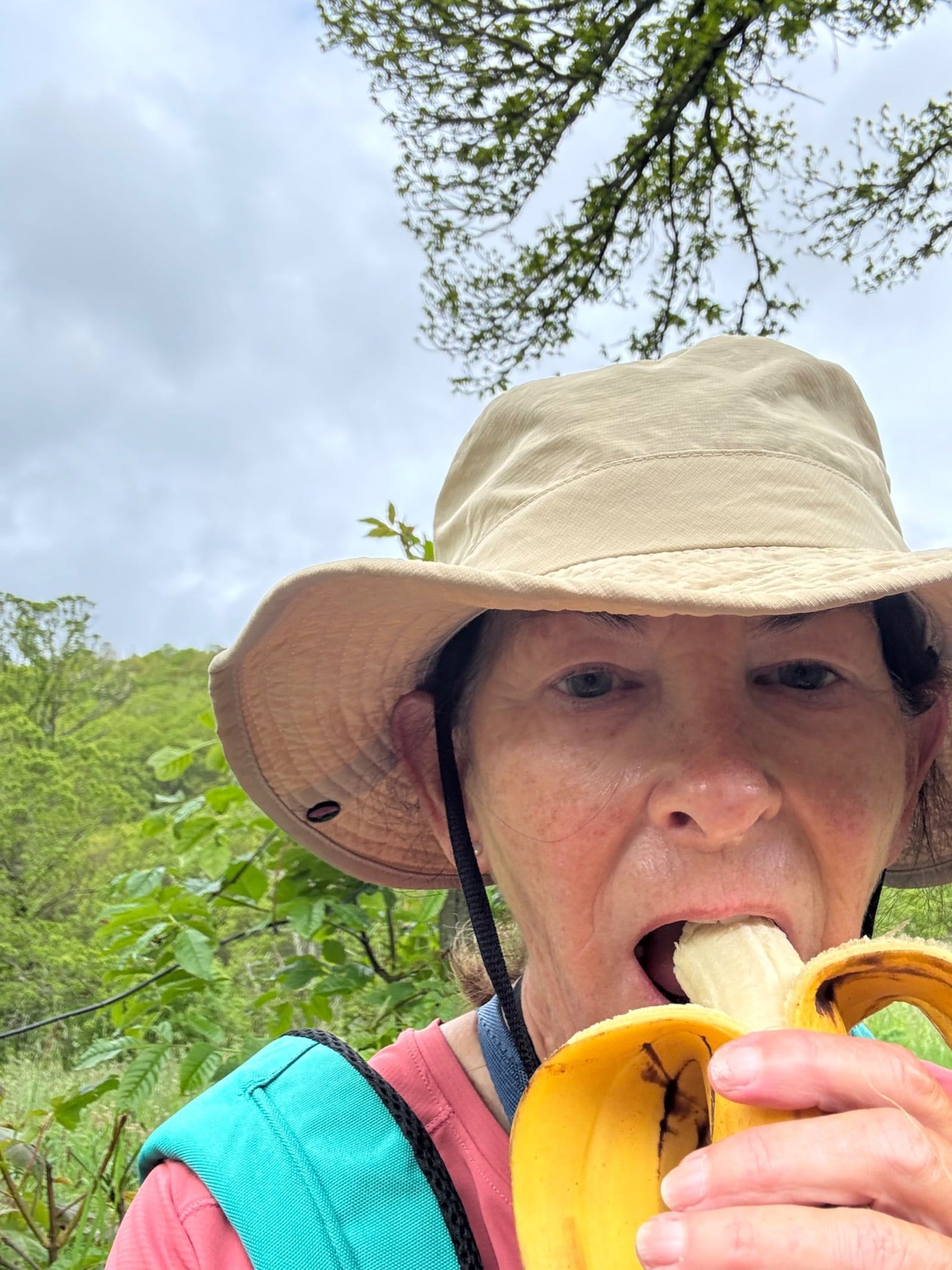 Pilgrim eating banana on foggy trail