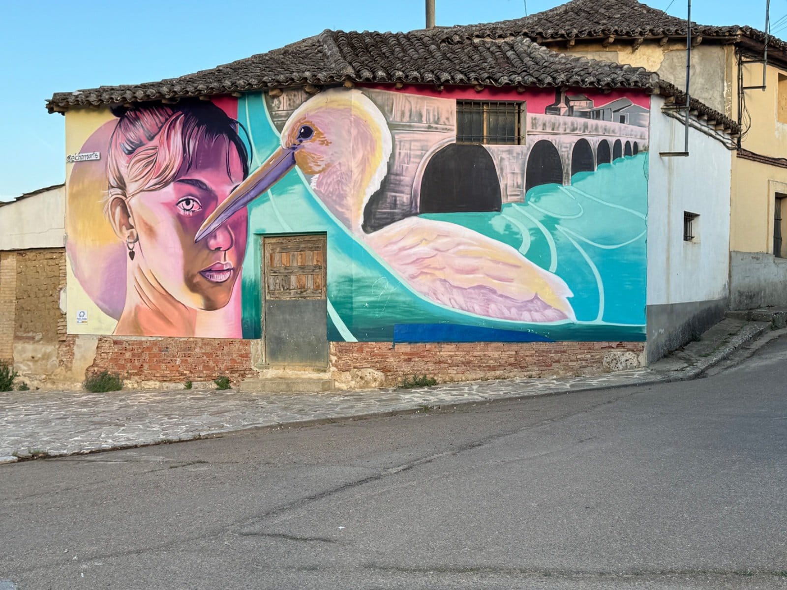 Mural of woman with pelican and stone bridge