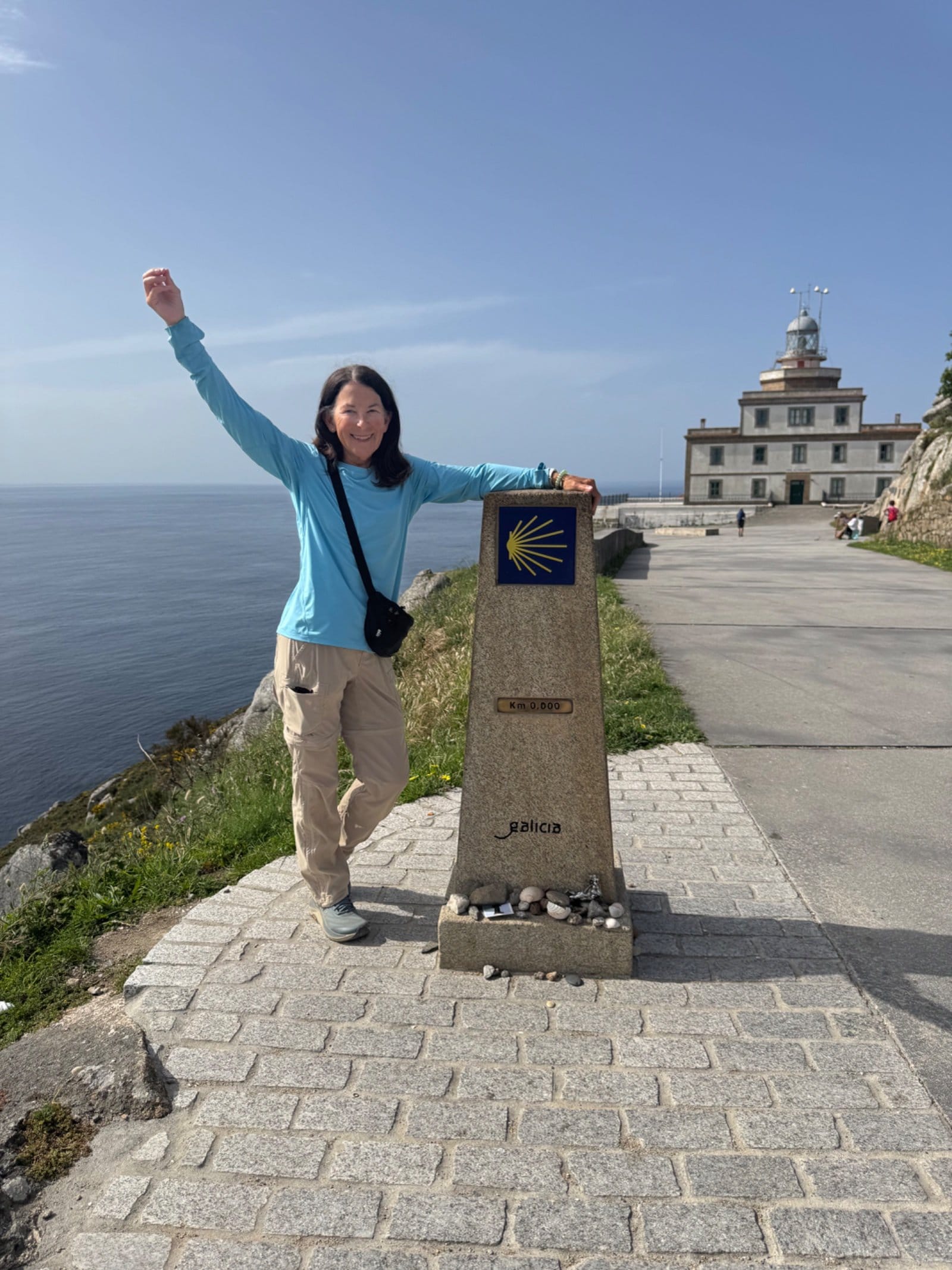 Shelley celebrating at Km 0.000 Camino marker