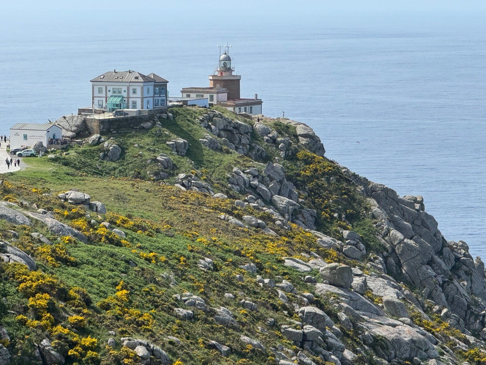 Finisterre lighthouse perched on rocky promontory above ocean