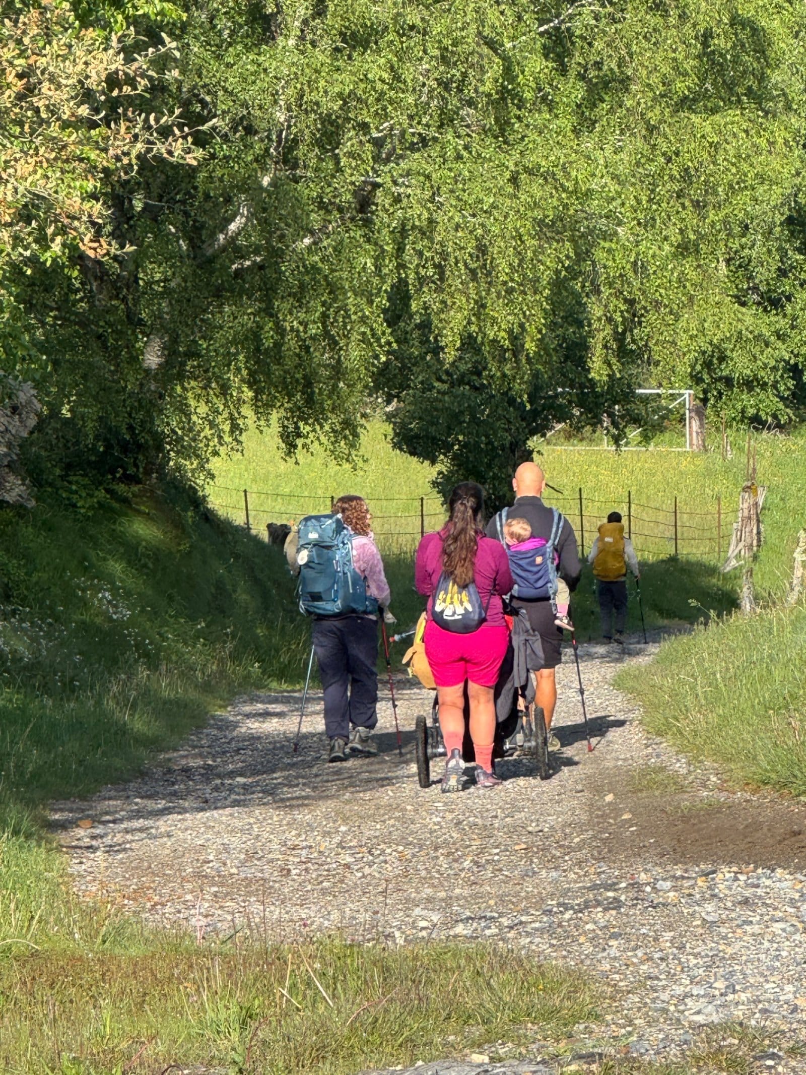 Pilgrims with jogging stroller walking toward Triacastela